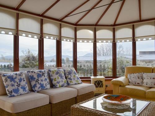 a living room with a couch and a table at Rowan Cottage in Aviemore