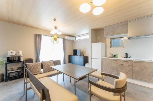a kitchen and living room with a table and chairs at SEIMU Kohama in Osaka