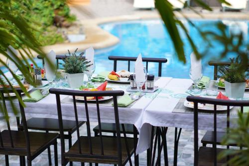 a table with plates of food on it next to a pool at Denika's Suites in Puerto Princesa City