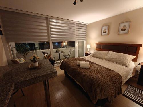 a bedroom with a bed and a large window at Depto centro de chillan con estacionamiento in Chillán
