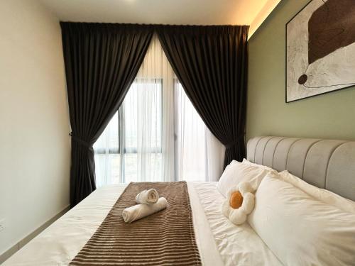 a bedroom with two towels on a bed with a window at Tulip Residences by Manhattan Group in Shah Alam