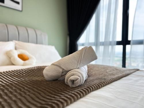 a stuffed animal is laying on a bed at Tulip Residences by Manhattan Group in Shah Alam