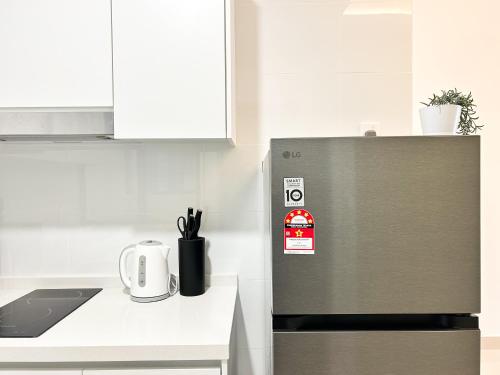 a kitchen with a stainless steel refrigerator in a kitchen at Tulip Residences by Manhattan Group in Shah Alam