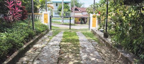 a gate in a garden with a walkway at El susurro del agua casa blanca exclusiva natural in Ibagué