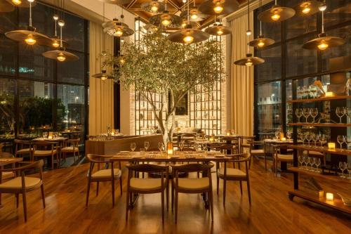 a restaurant with tables and chairs and large windows at Le Royal Meridien Abu Dhabi in Abu Dhabi