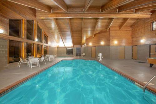 a large swimming pool in a building with tables and chairs at American Coralville Iowa City Iowa in Coralville