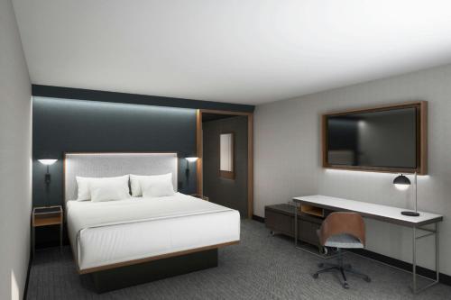 ルイストンにあるCourtyard Lewistonのベッド、机、テレビのある寝室