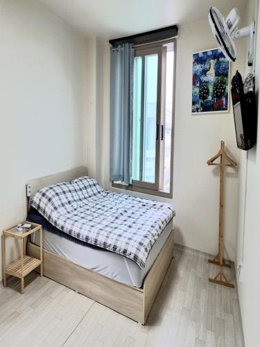 a small bedroom with a bed and a window at Wandonesia in Wando