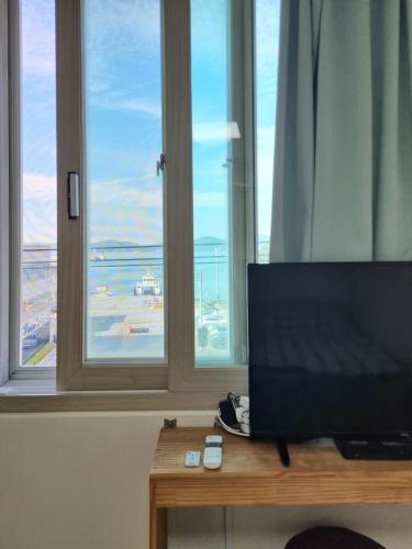 a television sitting on a table in front of a window at Wandonesia in Wando