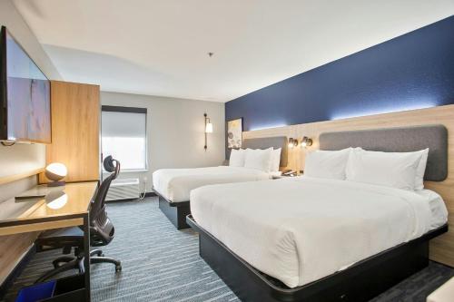 a hotel room with two beds and a desk at City Express by Marriott Duluth in Duluth