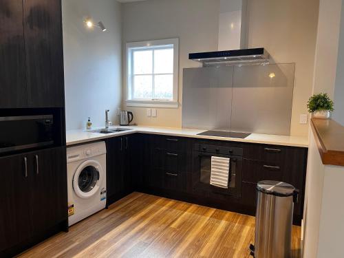 a kitchen with a sink and a washing machine at 298 Home in Christchurch