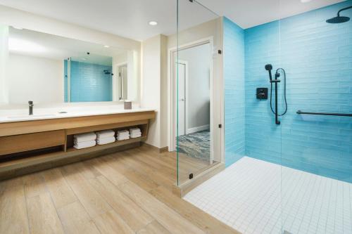 a bathroom with a glass shower and a sink at Courtyard by Marriott Oceanside Fort Lauderdale Beach in Fort Lauderdale