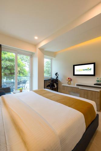a bedroom with a large bed and a flat screen tv at Limewood Signature - Golf Course Extension Road in Gurgaon