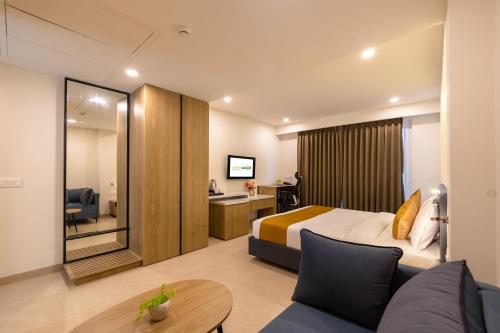 a hotel room with a bed and a couch at Limewood Signature - Golf Course Extension Road in Gurgaon