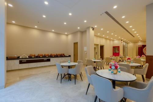 a restaurant with tables and chairs and a counter at Limewood Signature - Golf Course Extension Road in Gurgaon