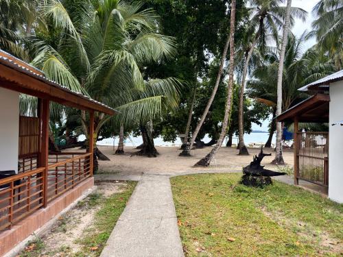 a walkway in front of a house with palm trees at Lemon Grass Resort & Spa in Havelock Island