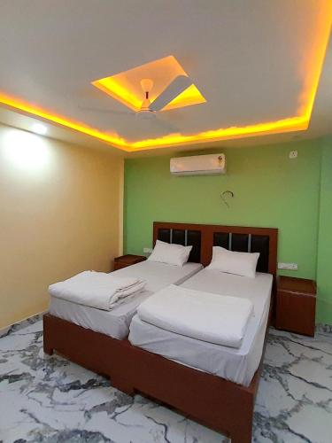 Un dormitorio con dos camas y un ventilador de techo. en Hotel The Prince Palace Near Mahabodhi Temple - Wifi and Parking Facilities, en Bodh Gaya