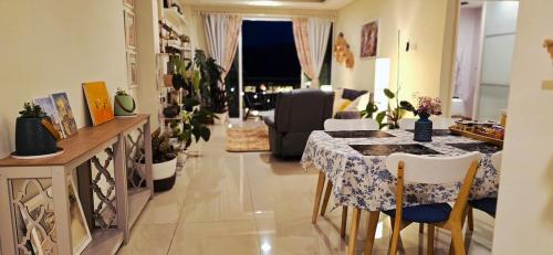 ein Wohnzimmer mit einem Tisch mit Stühlen und einer Couch in der Unterkunft #MyHighlandGetaway at OmniCassia Cameron Highlands in Cameron Highlands