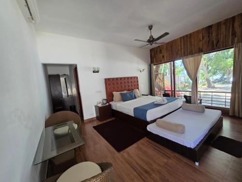 a bedroom with two beds and a balcony at Lemon Grass Resort & Spa in Havelock Island
