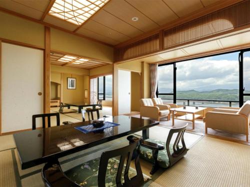 a living room with a table and a view of the ocean at Hotel Shion in Morioka