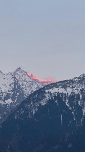a snow covered mountain range with snow covered mountains at Blabla House Himachal in Pulga