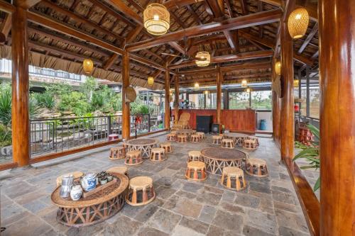 a patio with tables and chairs and a stage at Villa Nhà Ba Gian Hoà Lạc in Nam Giao