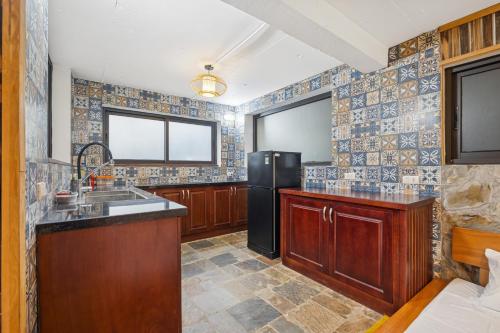 a kitchen with a sink and a refrigerator at Villa Nhà Ba Gian Hoà Lạc in Nam Giao