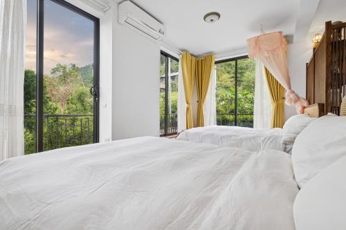 a bedroom with two beds and a large window at Villa Nhà Ba Gian Hoà Lạc in Nam Giao