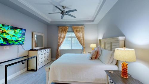 a bedroom with a bed and a ceiling fan at South Bay Beach Club #16 - 4 Bedroom 4 Bathroom Unit in George Town