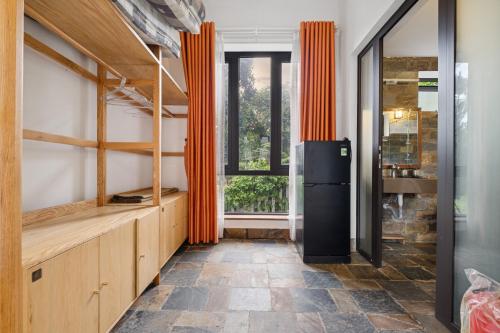 a kitchen with orange curtains and a refrigerator at Villa Nhà Ba Gian Hoà Lạc in Nam Giao