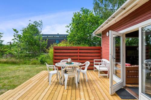 a patio with a table and chairs on a deck at Small Offline Holiday Home Near Grenaa Beach in Grenå