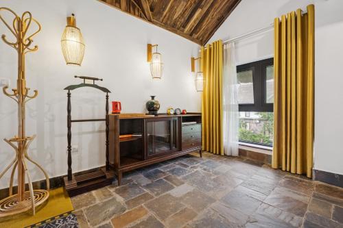a living room with a tv and a window at Villa Nhà Ba Gian Hoà Lạc in Nam Giao