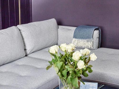 a white couch with a vase of flowers on a table at Alt-Na-Craig in Rothbury