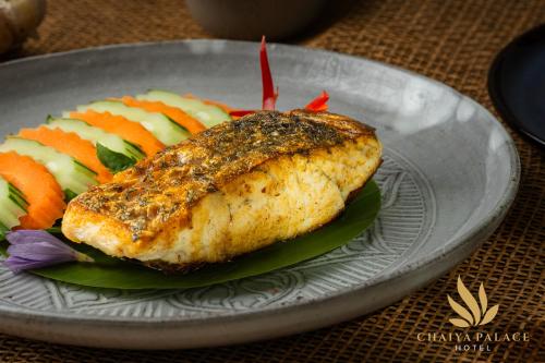 a plate of food with a piece of fish and vegetables at Chaiya Palace Hotel in Phnom Penh