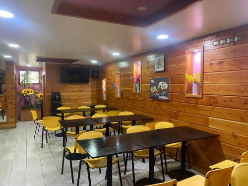 a restaurant with wooden walls and tables and chairs at Hostal Villarrica Centro in Villarrica