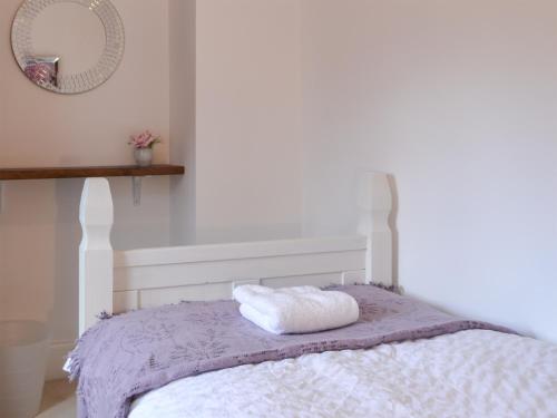 a white bed with a white blanket and a mirror at Crescent By The Sea in Newbiggin-by-the-Sea