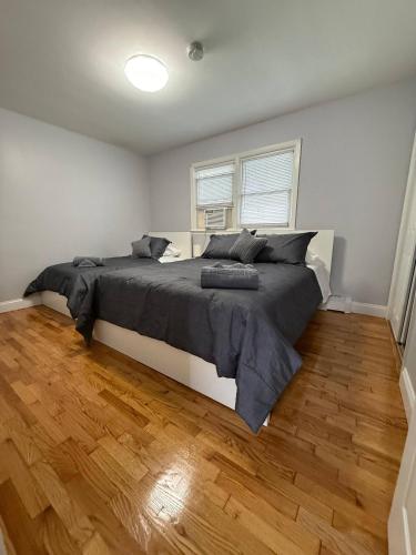 a bedroom with a large bed and a wooden floor at Modern 3BR Spacious & Bright in Hoboken