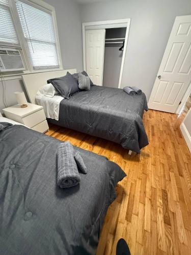 a bedroom with two beds and a wooden floor at Modern 3BR Spacious & Bright in Hoboken