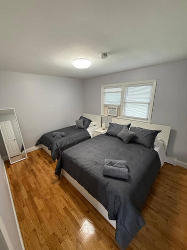 a bedroom with two beds with gray sheets at Modern 3BR Spacious & Bright in Hoboken