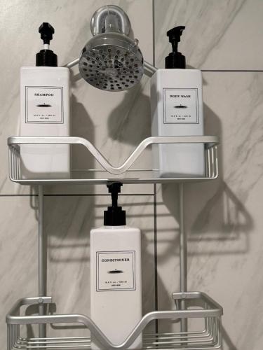 three bottles of soap on a shelf in a bathroom at Modern 3BR Spacious & Bright in Hoboken