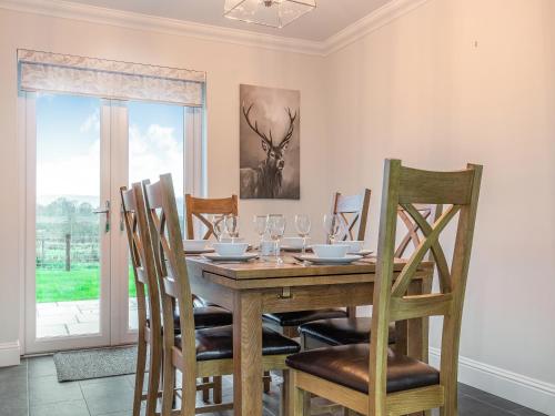a dining room with a wooden table and chairs at Fiadh Ruadh-Uk40008 in Gartmore