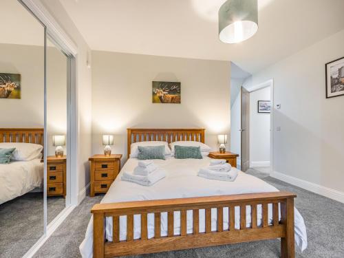 a bedroom with two beds and a mirror at Fiadh Ruadh-Uk40008 in Gartmore