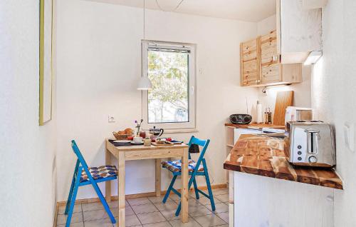 una cucina con un tavolo di legno e sedie blu di Ferienwohnung Rheinsberg a Kagar
