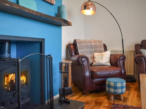 a living room with a chair and a fireplace at Seaview in Barvas