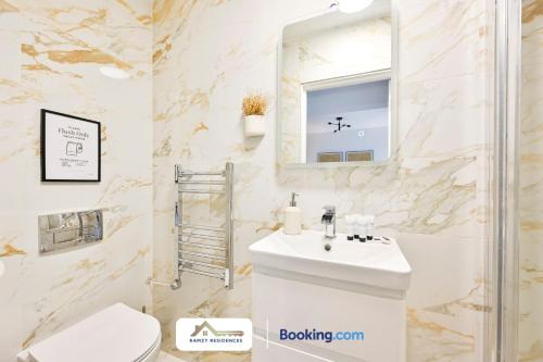 a white bathroom with a sink and a mirror at 1 Bedroom Apartments By Ramzy Residences Short Lets & Serviced Accommodation In Kent With Free Wifi in Sevenoaks