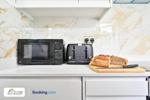 a microwave and a loaf of bread on a counter at 1 Bedroom Apartments By Ramzy Residences Short Lets & Serviced Accommodation In Kent With Free Wifi in Sevenoaks