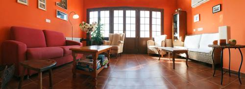 a living room with orange walls and red furniture at Hotel Rural Suquin in Navia