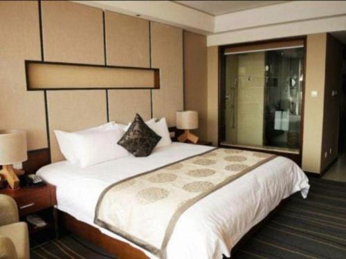 a hotel room with a large bed and a window at The Prosperous City Hotel Weifang in Weifang