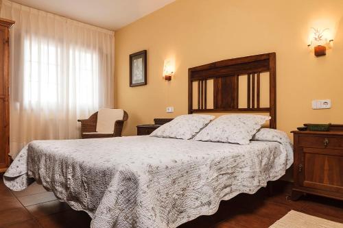 a bedroom with a large bed with a wooden headboard at Hotel Rural Suquin in Navia