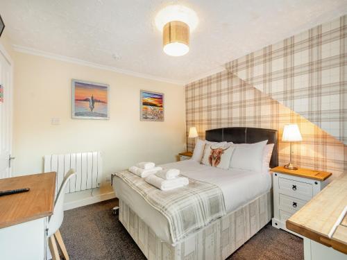 a bedroom with a bed and a desk and a bed sidx sidx sidx at Argyle House in Rothesay